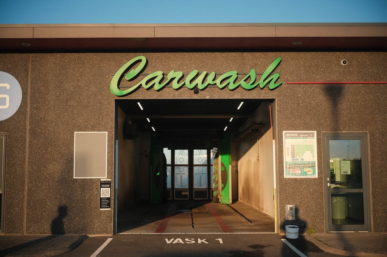 hero-img-02 Exterior view of a carwash in Norway, featuring modern design and ambient sunset lighting.