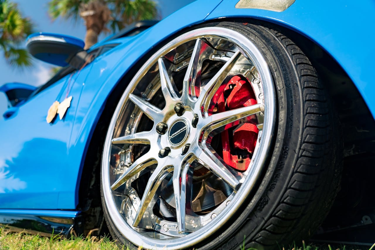 our-services-3 Dynamic shot of a blue sports car highlighting its chrome rims and red brake calipers.