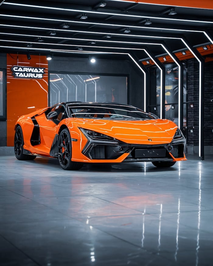why-choose-us Eye-catching orange sports car displayed in a modern Ankara showroom, featuring sleek design and neon lighting.